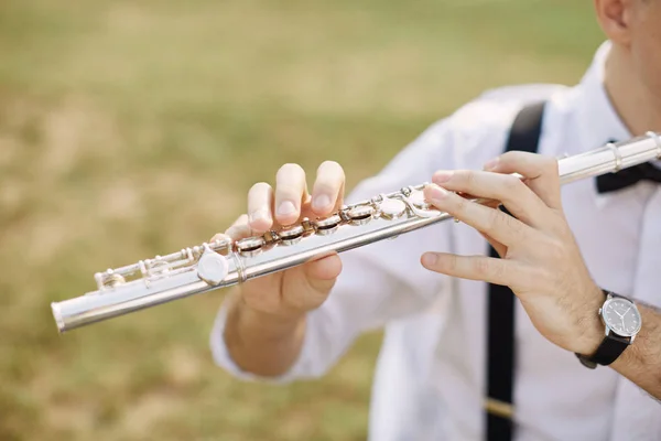 Ung man spelar en klarinett eller flöjt — Stockfoto