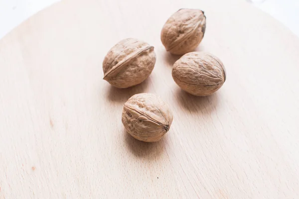 Орехи на коричневой деревянной тарелке крупным планом . — стоковое фото
