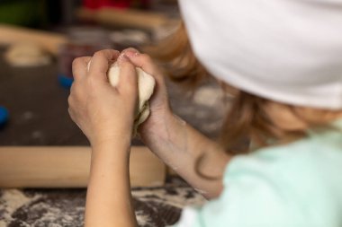 Kız hamuru buruşturur.