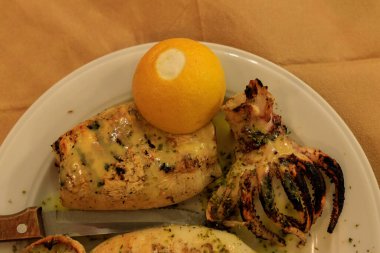 grilled squid on a plate with lemon
