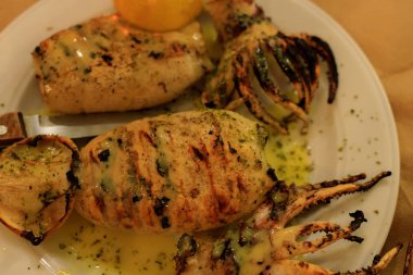 grilled squid on a plate with lemon