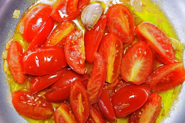 Stekta tomater, vitlök och lök i pannan. — Stockfoto