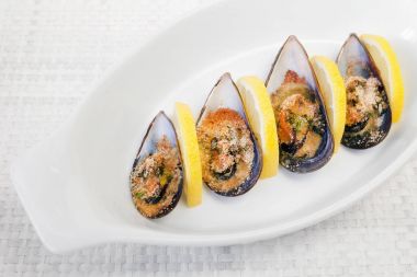 Graten midye. Kızarmış midye dilim limon, rendelenmiş pan ve maydanoz tarafından eşlik fırında pişmiş. 