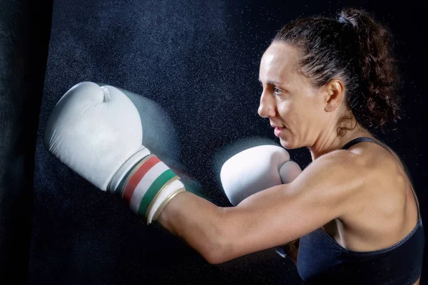 A boxer woman throws a fist. Fist in the sack.