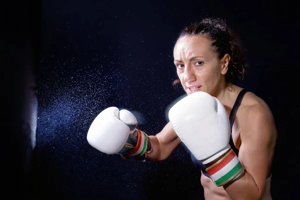 A boxer woman throws a fist. Fist in the sack.