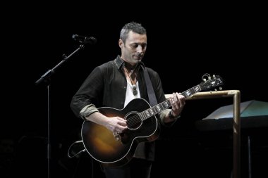 Alex Britti gitar çalıyor ve şarkı söylüyor