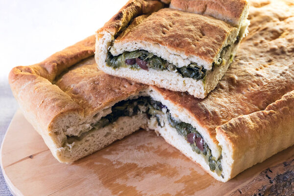 Pizza stuffed with escarole, olives and capers.