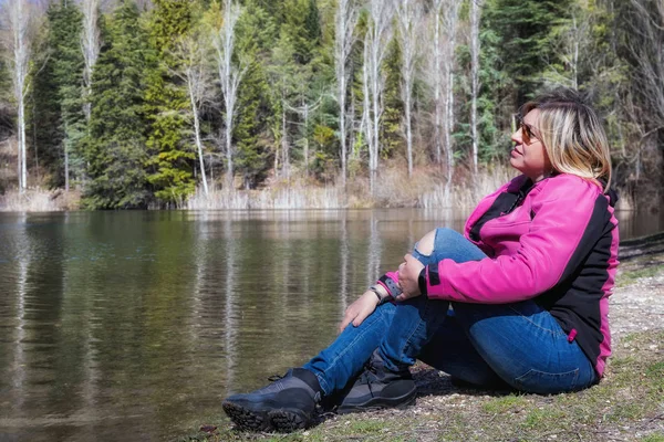 Büyüleyici bir doğal ortamda göl kenarında kadın sunbathes.