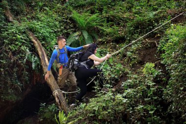 Bir orman yolu bir ip yardımı ile yürüyüşçü tırmanmak