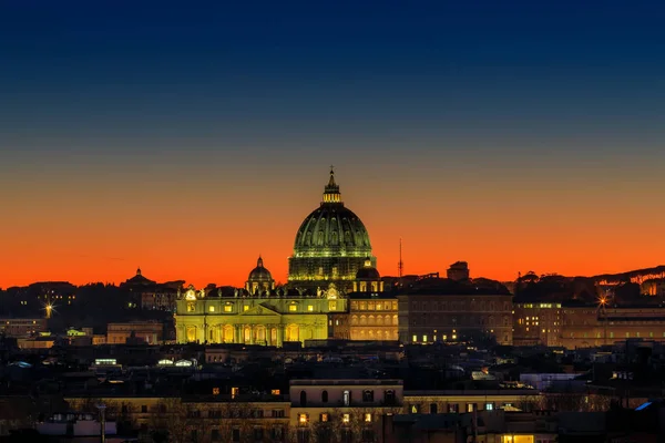 Sunset on the skyline of Rome city, with the dome of St. Peter\'s Cathedral in the center. Intense yellow-orange color and horizon against the light.