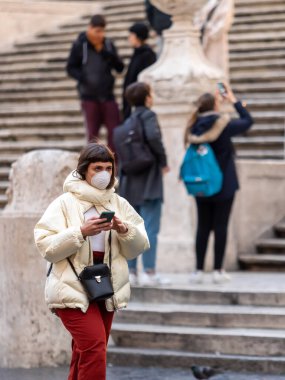 Rome, Italy - March 4, 2020: A girl walks the streets of the center wearing a protective mask on her face. Coronavirus emergency in the city.