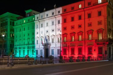 Roma, İtalya - 24 Mart 2020: Palazzo Chigi, İtalyan hükümetinin merkezi, binanın ön cephesi İtalyan bayrağının renkleriyle aydınlandı. Coronavirus acil İtalya.