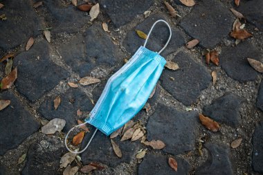 Roma, İtalya - 10 Mayıs 2020: Koruyucu bir maske yolda, yerde bırakıldı. Koronavirüs salgınının sınırlamalarının sonunun sembolü.