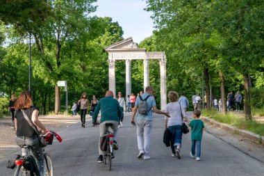Roma, İtalya - 10 Mayıs 2020: Villa Borghese, halk parkı caddesinde insanlar bisiklete biniyor ya da geziniyor. Salgının sona ermesinden sonraki ilk pazar serbest..