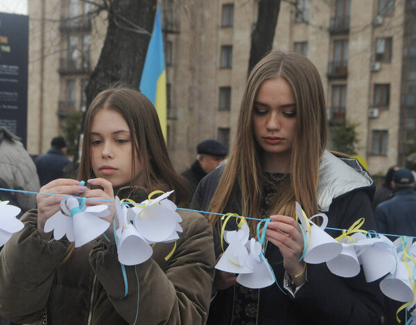 Girls hang angels during events to commemorate the memory of Heroes of Heavenly Hundred, on Institutskaya Street, in Kiev, February 20, 2020. 