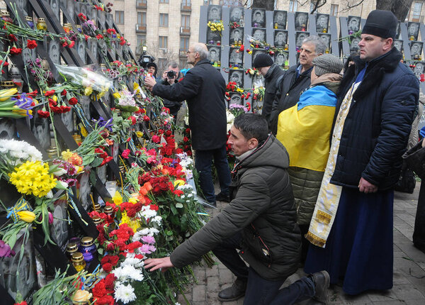 People lay flowers at the memorial of activists of the Euromaidan or Heroes of Heavenly Hundreds who were killed in Kiev, February 20, 2020. 