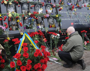 Bir adam, 20 Şubat 2020 'de Kiev' de Avrupa Meydan aktivistlerinin ya da Cennetin Kahramanları 'nın anısına çiçek bırakıyor.. 