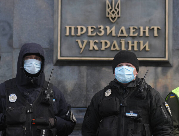 Украинские полицейские в масках в качестве меры предосторожности против распространения коронавируса ковид-19 во время марша. Украинские волонтеры, посвященные Дню волонтера, в Киеве, 14 марта 2020 года
