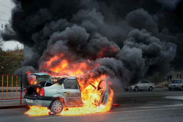 El coche arde con llama y humo en la calle —  Fotos de Stock