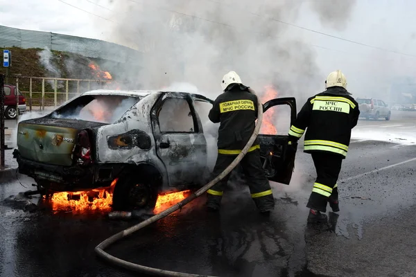 Пожарные тушат горящий автомобиль в России — стоковое фото