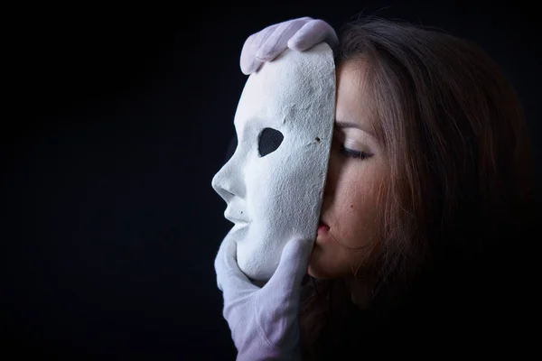 Menina morena está segurando uma máscara de teatro — Fotografia de Stock