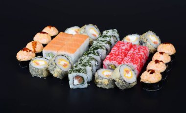 Japon pirinç balık, sebze ve zencefil ile karanlık bir arka plan üzerinde rulo