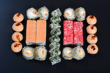 Japon pirinç balık, sebze ve zencefil ile karanlık bir arka plan üzerinde rulo