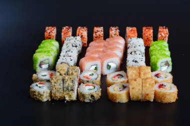 Japon pirinç balık, sebze ve zencefil ile karanlık bir arka plan üzerinde rulo