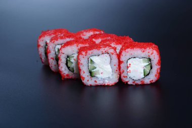 Japon pirinç balık, sebze ve zencefil ile karanlık bir arka plan üzerinde rulo