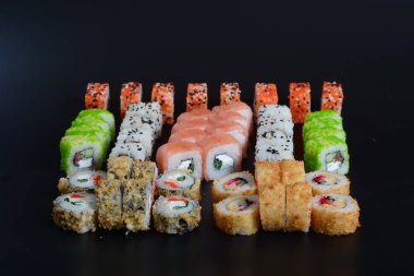 Japon pirinç balık, sebze ve zencefil ile karanlık bir arka plan üzerinde rulo