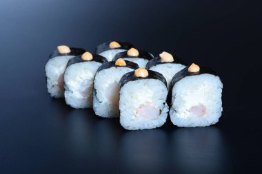 Japon pirinç balık, sebze ve zencefil ile karanlık bir arka plan üzerinde rulo