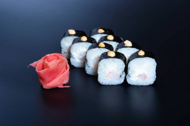 Japon pirinç balık, sebze ve zencefil ile karanlık bir arka plan üzerinde rulo