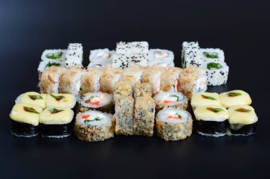 Japon pirinç balık, sebze ve zencefil ile karanlık bir arka plan üzerinde rulo