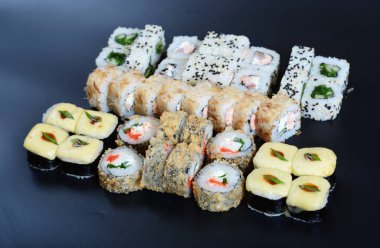 Japon pirinç balık, sebze ve zencefil ile karanlık bir arka plan üzerinde rulo