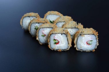 Japon pirinç balık, sebze ve zencefil ile karanlık bir arka plan üzerinde rulo