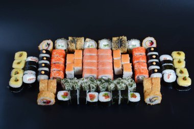 Japon pirinç balık, sebze ve zencefil ile karanlık bir arka plan üzerinde rulo