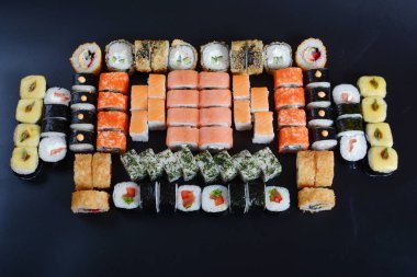 Japon pirinç balık, sebze ve zencefil ile karanlık bir arka plan üzerinde rulo