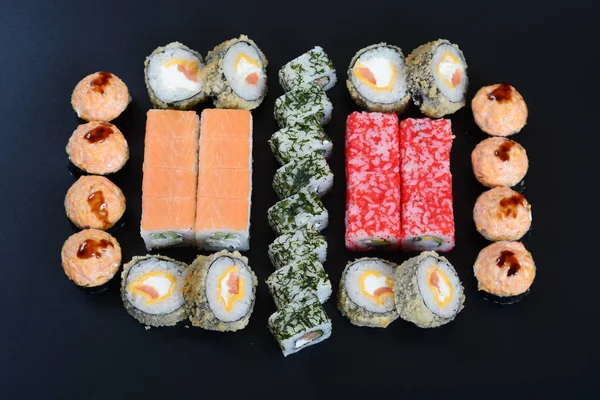 Japon pirinç balık, sebze ve zencefil ile karanlık bir arka plan üzerinde rulo