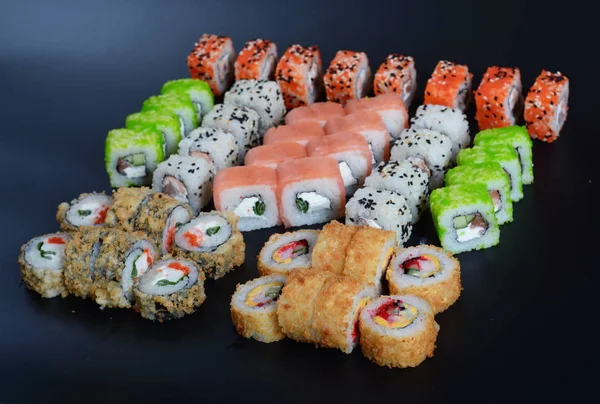 Japon pirinç balık, sebze ve zencefil ile karanlık bir arka plan üzerinde rulo