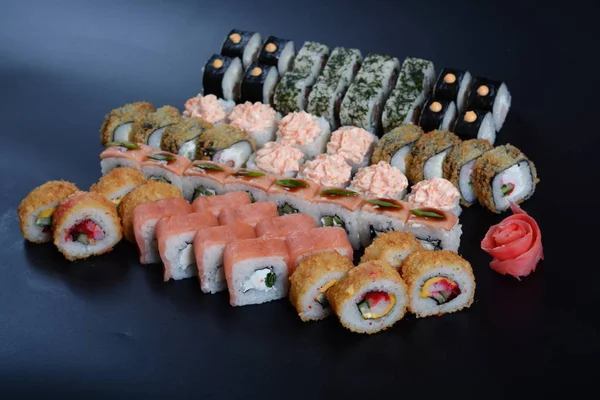 Japon pirinç balık, sebze ve zencefil ile karanlık bir arka plan üzerinde rulo