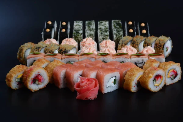 Japon pirinç balık, sebze ve zencefil ile karanlık bir arka plan üzerinde rulo