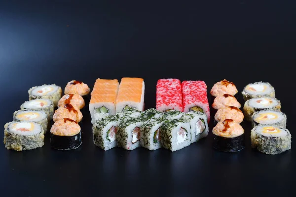 Japon pirinç balık, sebze ve zencefil ile karanlık bir arka plan üzerinde rulo