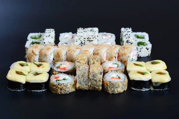 Japon pirinç balık, sebze ve zencefil ile karanlık bir arka plan üzerinde rulo