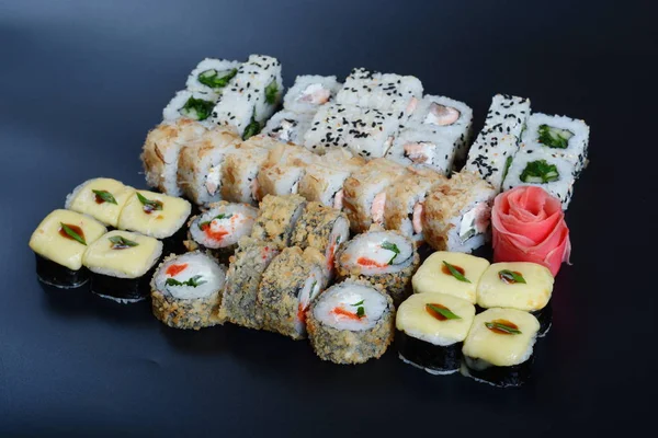 Japon pirinç balık, sebze ve zencefil ile karanlık bir arka plan üzerinde rulo