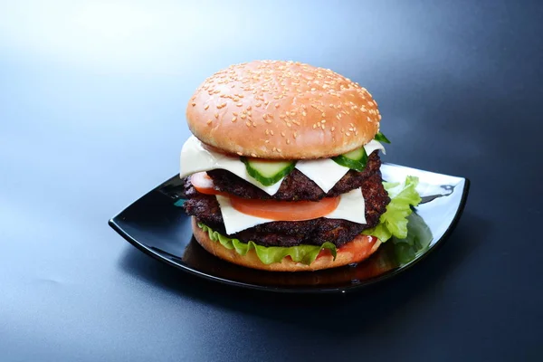サラダ トマトと暗い背景にチーズ ハンバーガー — ストック写真