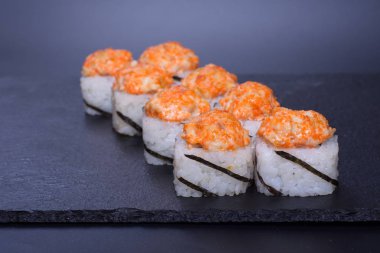 Japon pilavı ve deniz ürünleri kreması koyu bir zemin üzerinde uzanıyor.