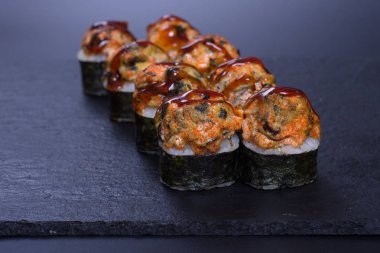 Japon pilavı ve deniz ürünleri kreması koyu bir zemin üzerinde uzanıyor.