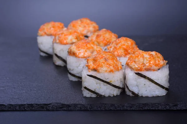 Japanese rice rolls with delicate seafood cream lie on a dark background