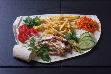 Tavuk etli, otlu ve sebzeli salata hamur tortillasında yatıyor.