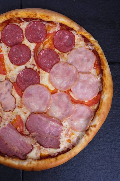 Italienische Pizza Mit Wurst Räucherfleisch Und Gemüse Liegt Auf Dunklem — Stockfoto